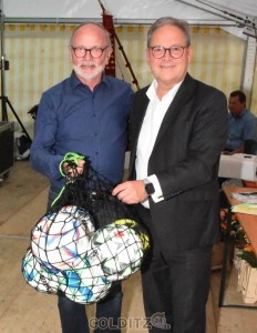 Hermann Winkler (re.), Vize-Präsident des DFB  übergibt Harald Müller ein Netz voller Bälle mit diesem ganz besonderen.