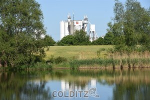 Blick auf die Verarbeitungsanlage über den Stausee